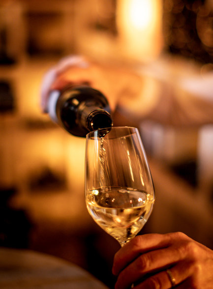 Anna Lercher pours wine into a glass in the wine cellar. Anna Lercher pours wine into a glass in the wine cellar.