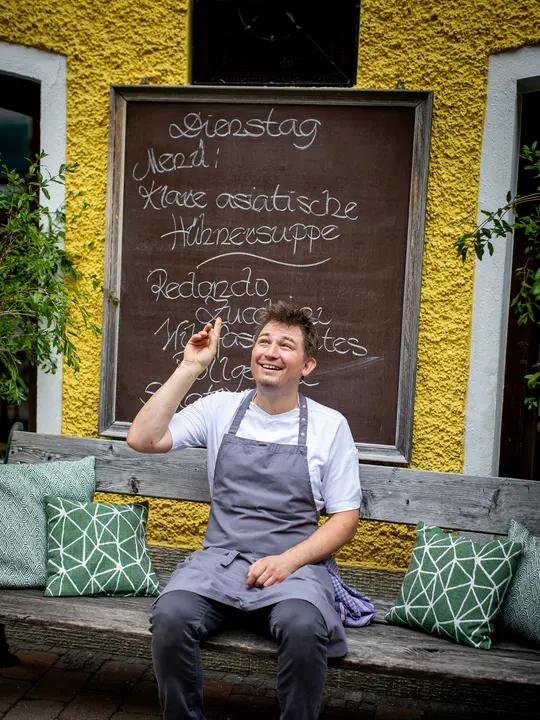 Daniel Leitner in front of the menu board.